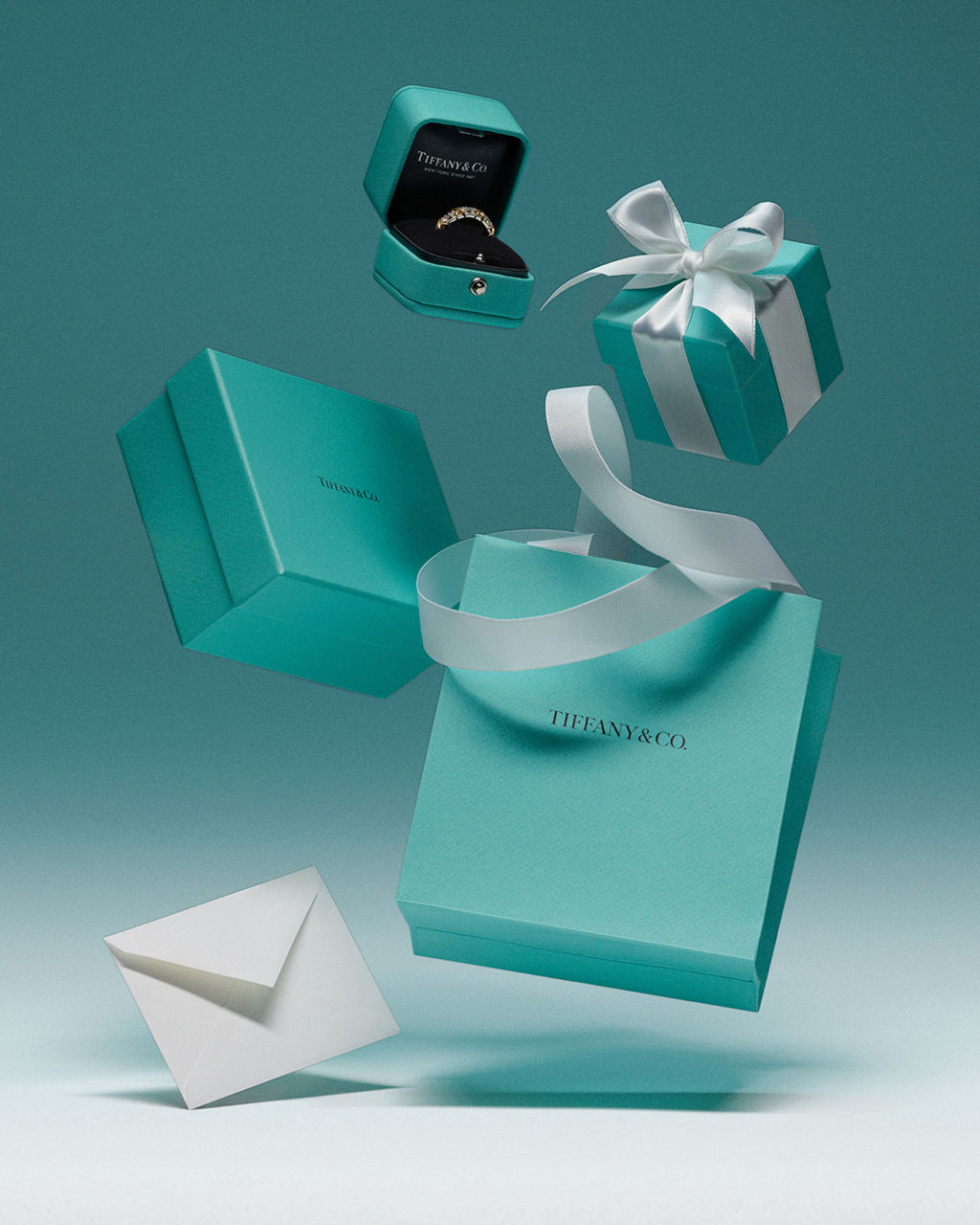 Scatole, sacchetto e nastro Tiffany nel caratteristico azzurro, sospesi su fondo verde acqua