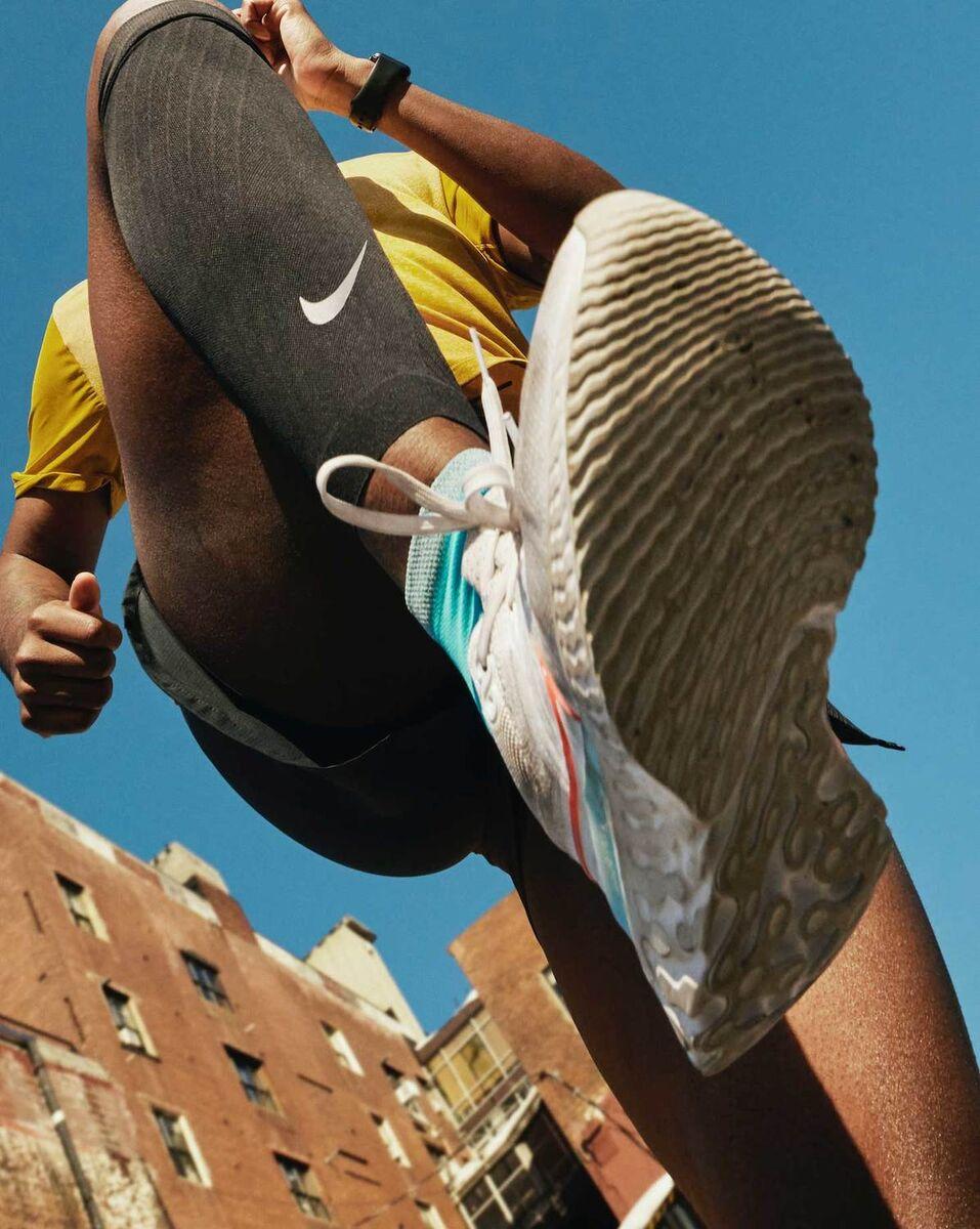 Atleta ripreso dal basso in azione: sulla calzamaglia lo Swoosh Nike appare piccolo